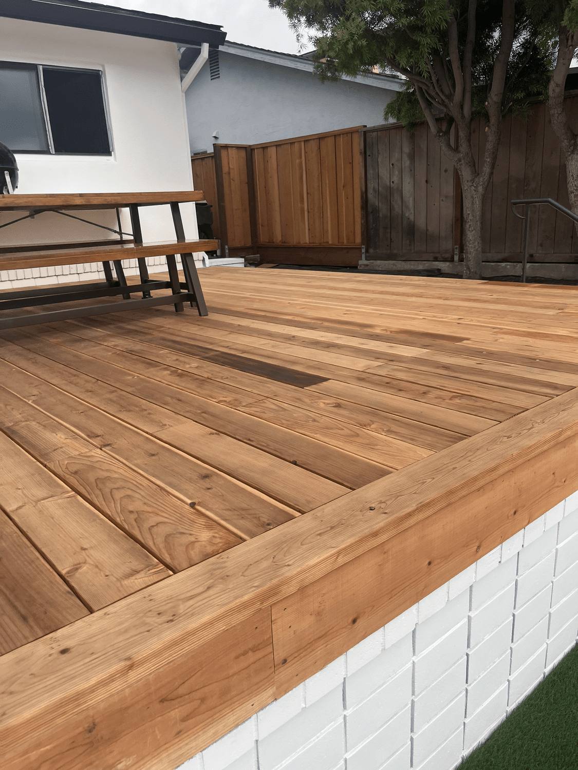 Deck boards laid in a diagonal pattern along a fence line