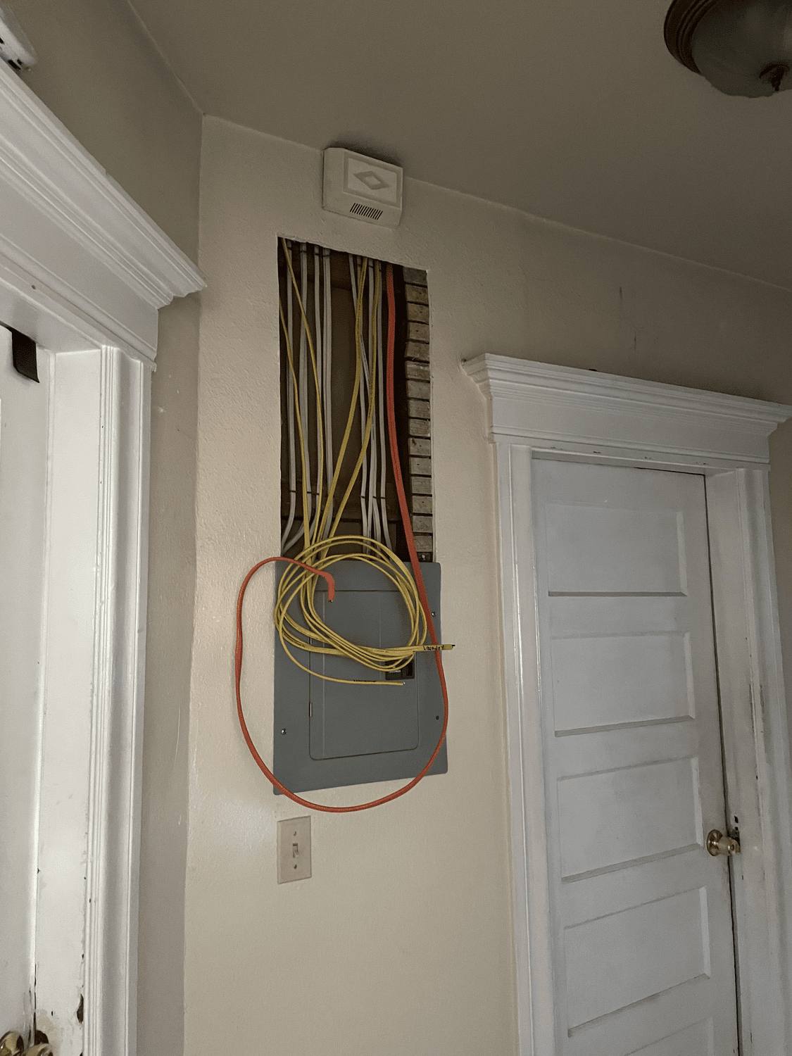 Electrical sub-panel with new wiring installed in a hallway