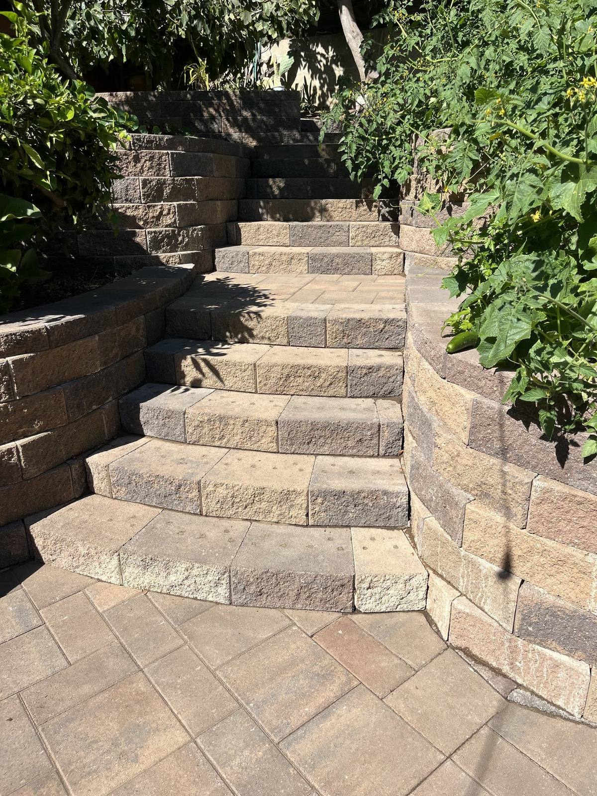 Paver steps climbing between stone retaining walls