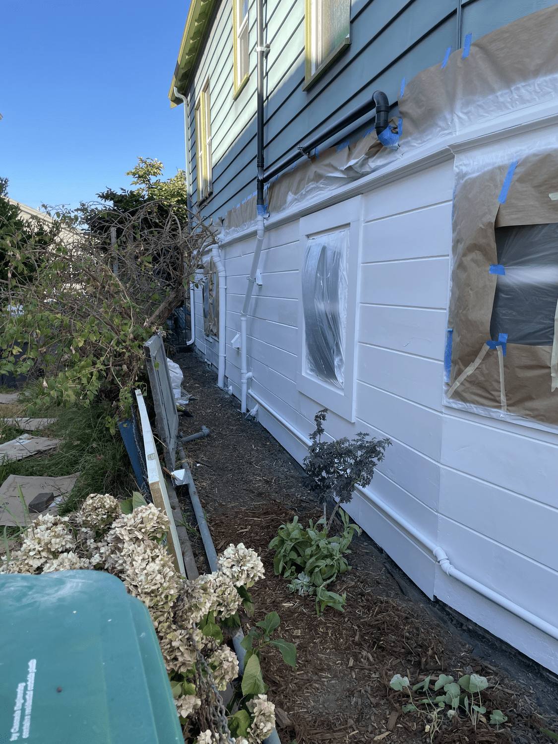 Exterior siding masked and primed during surface preparation