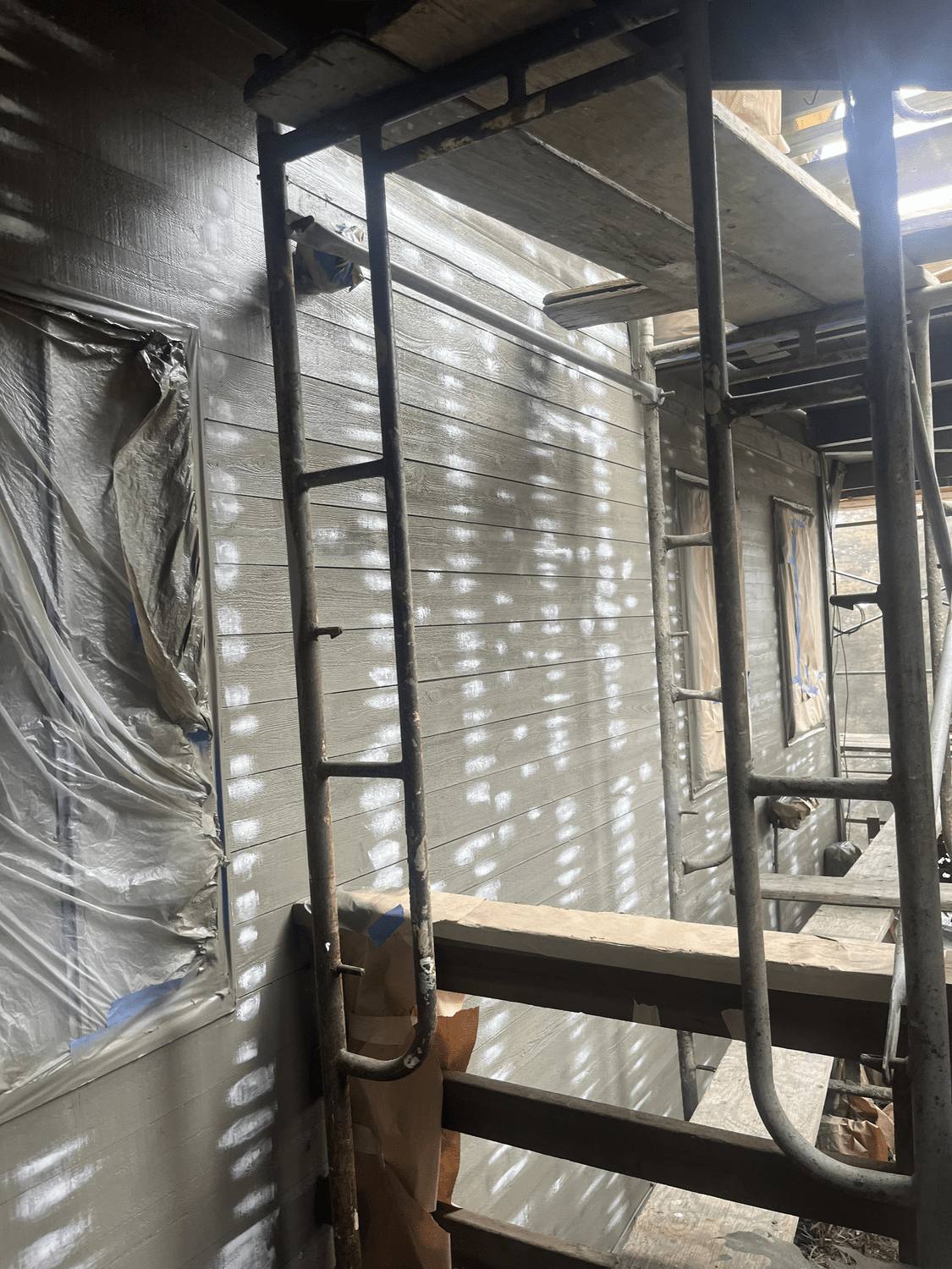 Exterior covered and masked with plastic sheeting before painting
