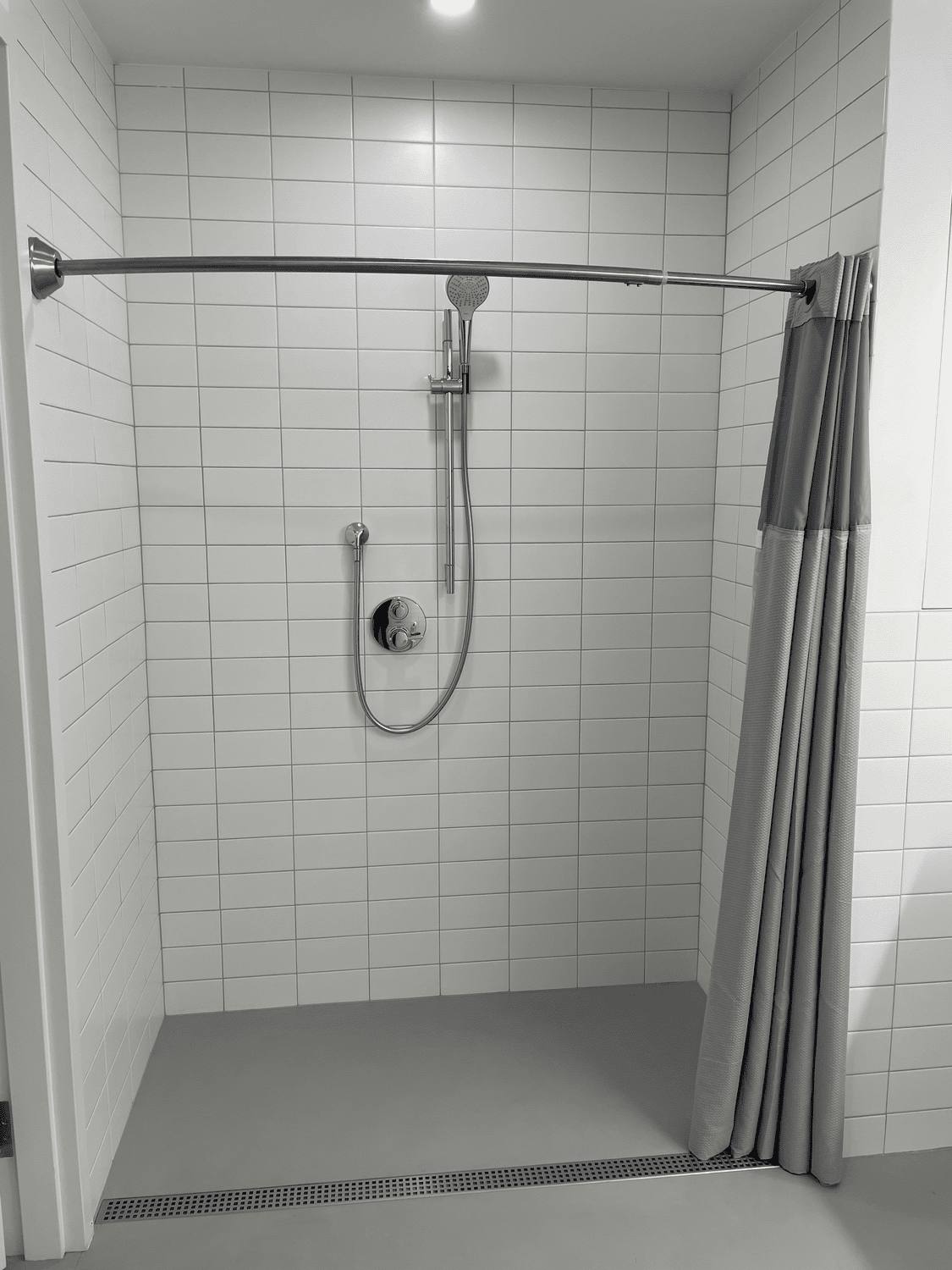 Walk-in tile shower with low threshold and curved rod
